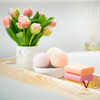 beautiful colourful tilley bath bombs on bath tray with flowers and soaps
