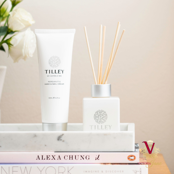 Tilley - Pink Lychee Candle & Reed Diffuser styled on table books plant