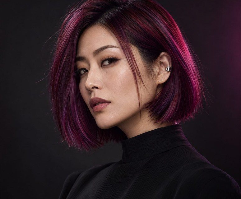 A woman with a sleek bob in magenta, raspberry and burgundy fashion colour