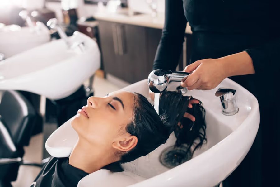 A client having her hair washed before a keratin treatment